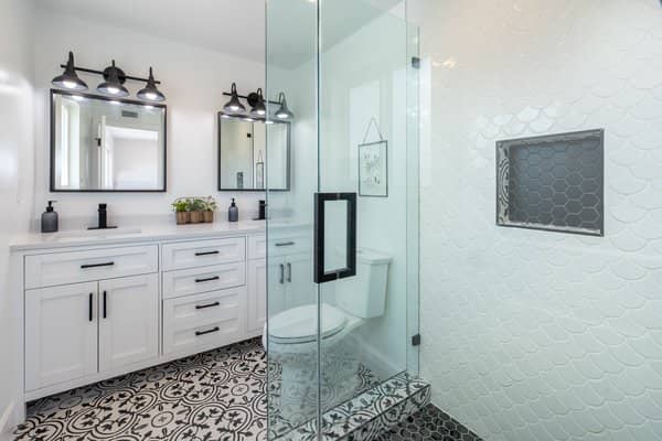 Updated bathroom with artistic pattern tile flooring and glass enclosed shower